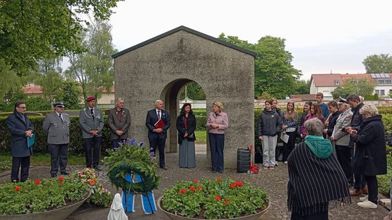 Personen vor einem Torbogen. Gedenken an das Kriegsende 1945 in Regensburg